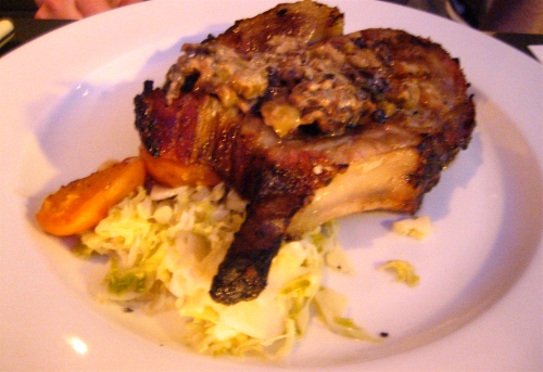 Spit-roasted pork loin with butter, roasted apricots, cabbage, crème fraîche and olives